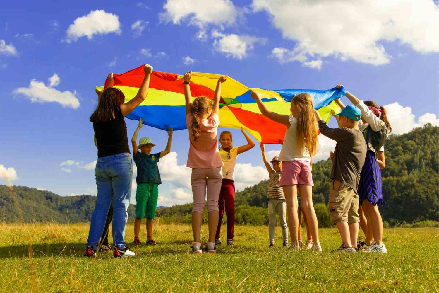 Children playing with colorful parachute